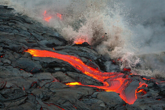 View of volcanic eruption with lava flow and smoke, Big Island, Hawaii, United States.