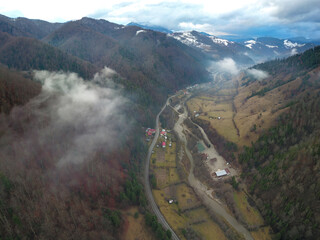 Aerial drone panorama above a valley inside a hilly region. Winter season, the mountains are...