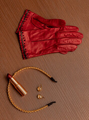 Elegant red leather gloves with gold jewelry and make up accessories