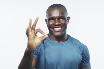 Okay sign, exercise and portrait of black man on a white background for training, workout and fitness. Sports, emoji and happy male athlete for gym promotion, like and yes to wellness in studio