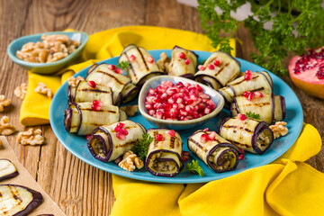 Delicious appetizer of grilled eggplants. Wrapped in rolls with nut paste. Served with pomegranates.