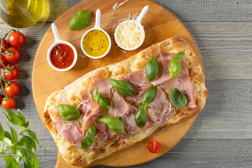 Traditional Roman pinsa with ham and basil. - 788209184