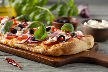 Traditional Roman pinsa with feta cheese, peppers and black olives. - 788210367