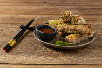 Portion of spring rolls stuffed with meat. Served with sauce.