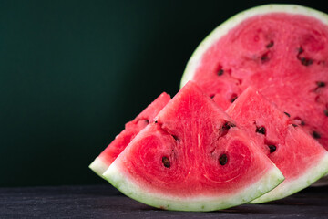 Pieces of refreshing watermelon on a dark wood background. Close-up photo. Fruit texture - obrazy, fototapety, plakaty
