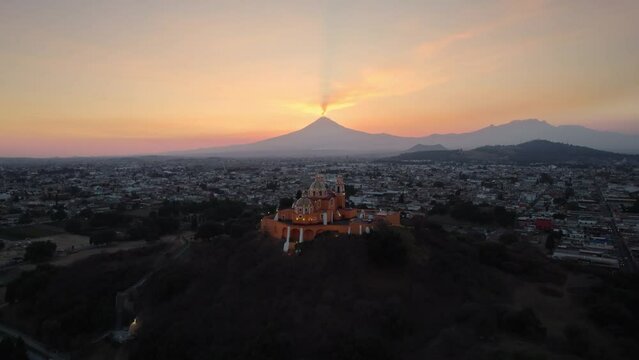 Aerial drone view of a church in Cholula and Popocatepetl volcano in Mexico.