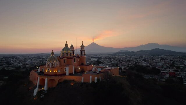 Aerial drone view of a church in Cholula and Popocatepetl volcano in Mexico.