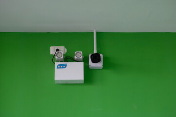 An emergency power supply and CCTV cameras are installed on the green wall.