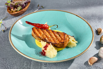 Salmon Steak with Creamy Mashed Potatoes and a Sprinkling of Spices on a Ceramic Plate