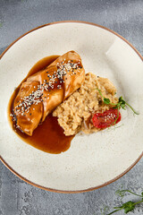 Chicken fillet with mushroom risotto and sesame seed garnish, an appetizing top view of a classic dish