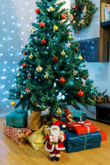 Fototapeta na wymiar Santa and elves figurines near colorful gifts lying on the floor under the Christmas tree