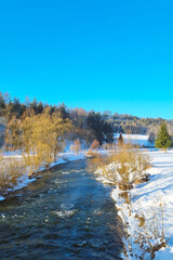 Snow-Covered Forest With River Flowing Through - 788220365