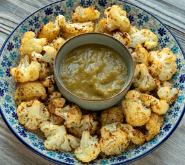 Top view of roasted cauliflower with tomatillo salsa. Homemade healthy vegan food. 