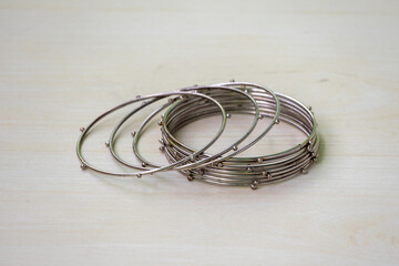 Antique, shiny silver lady bangles with round balls on a wooden background. Beautiful woman's...