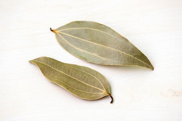 Two dried bay leaves (Laurus nobilis) isolated on a white background. It is also known as Tejpata,...