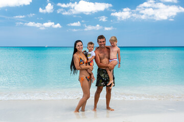 mom and dad with children, playing with kids, family on the beach, swimming in the ocean, vacations...