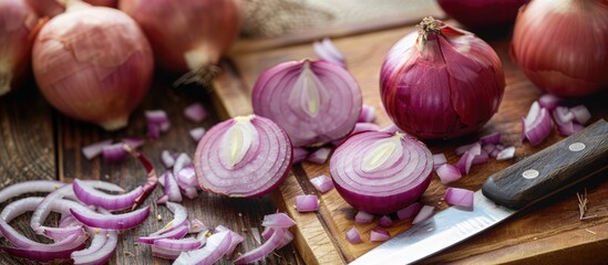 Fresh onion and sliced onion on cutting board with a kitchen knife.