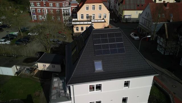 Aerial photo of a beautiful house in a small German town with new solar panels on the roof.