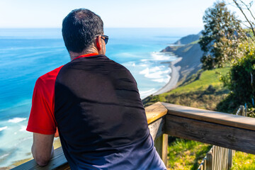 A tourist looking at the beautiful coastal landscape in the flysch of Zumaia, Gipuzkoa. Basque...