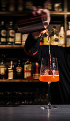 Bartender pouring a cocktail at a bar
