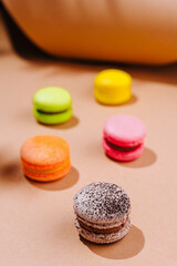 Colorful macarons on a warm beige background