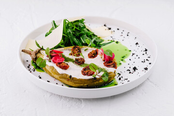Gourmet stuffed eggplant with fresh greens plate