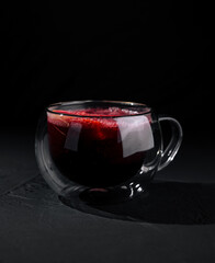 Elegant glass of red tea on dark background