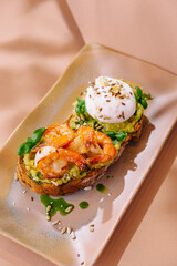 Gourmet avocado toast with shrimp and poached egg