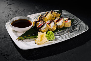 Gourmet sushi rolls on elegant plate with sauce