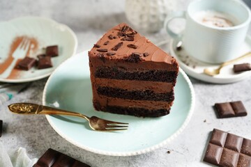 Homemade chocolate layer cake with mousse filling served on a plate, selective focus