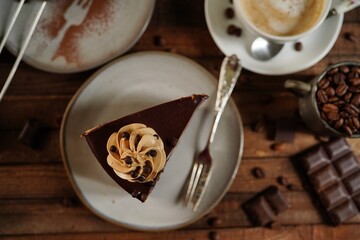 Slice of homemade Chocolate coffee crunch cake on dark wooden background, selective focus