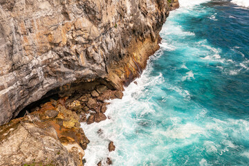 White foam waves breaks against rocks. Travel concept. Klungkung, Bali, Indonesia