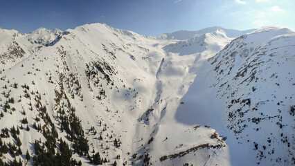 Aerial drone panorama above Fagaras mountain peaks. Springtime season, the crests are covered with...