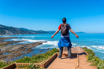 A tourist hiker visiting the Flysch Basque Coast geopark in Zumaia at the Algorri Viewpoint,...