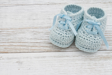 Blue baby booties on weathered wood