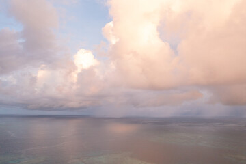 Sunrise on the island of Fiji over calm water. Gentle pinkish blue cloudy landscape over the ocean.