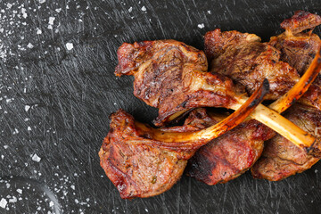 Lamb chops. Close up photo with some lamb chops grilled on barbecue and placed on a black plate...