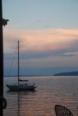 Beautiful sunset at the sea, boat floating on still water