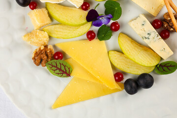 Cheese platter. Cheese appetiser dish. Close up photo with a delicious plate made with different type of cheese like gouda, brie, camembert and other French cheese.