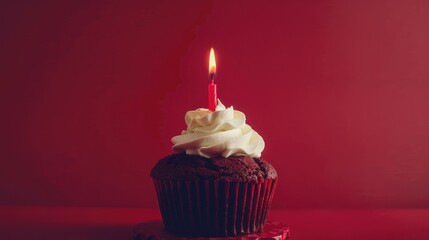 Birthday cake with lit candle against a red background. Festive atmosphere
