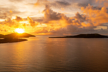 Golden sunset over ocean with incredible colorful sky background. Mountains with sun's rays. Fiji.