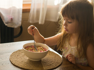 child having breakfast with corn flakes and milk