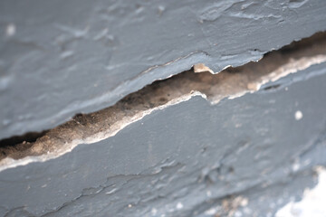 Large cracks in the gray cement wall, Close up view
