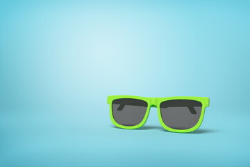 Neon green sunglasses on light blue backdrop