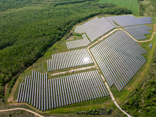 drone view of a solar power station next to a forest during summer. Renewable energy meets nature...