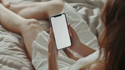 young woman lying on her bed and using mobile phone.