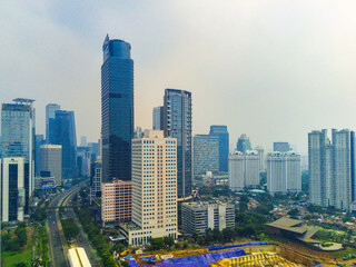 Aerial view of cityscape on Jalan Jenderal Sudirman in Jakarta, Indonesia. Tall skyscrapers line the busy street.