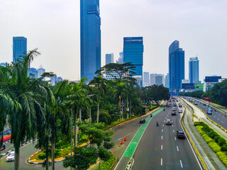 Aerial view of cityscape on Jalan Jenderal Sudirman in Jakarta, Indonesia. Tall skyscrapers line the busy street.