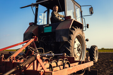 Portrait of satisfied farmer sitting in a tractor preparing to cultivate the land with a tractor.