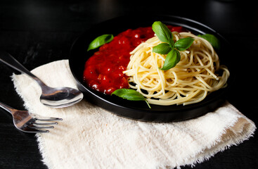 Spaghetti with tomato sauce. on a black background. dinner